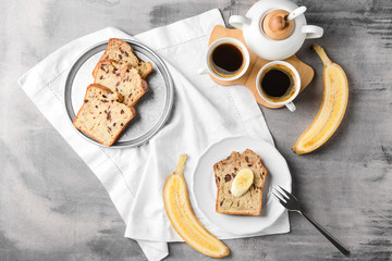 Tasty banana bread with coffee on grey table