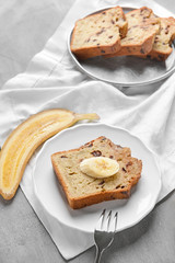 Plate with tasty banana bread on grey table