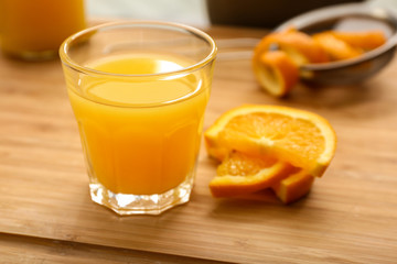 Glass of freshly squeezed orange juice on wooden table