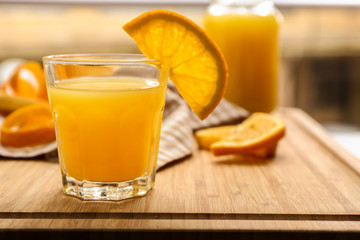Glass of freshly squeezed orange juice on wooden table