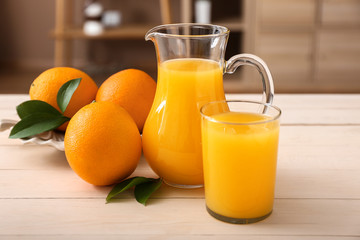 Glass and jug of freshly squeezed orange juice on table