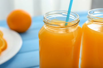 Mason jars of freshly squeezed orange juice on table
