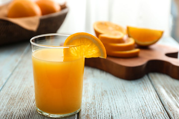 Glass of freshly squeezed orange juice on wooden table