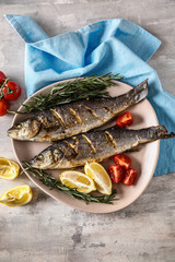Plate with tasty cooked fish on light table