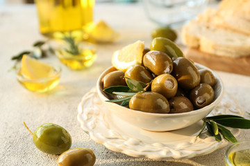 Bowl with tasty olives on grey background