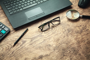 Office desk. Laptop, calculator, glasses, pen. Business concept