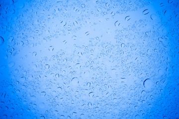 Rain droplets on blue glass background, Water drops on blue glass.