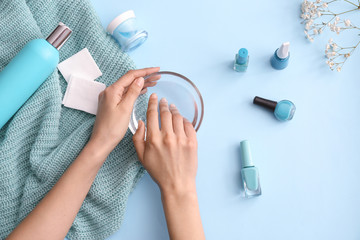 Woman doing manicure on color background