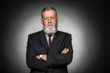 Handsome mature businessman on grey background