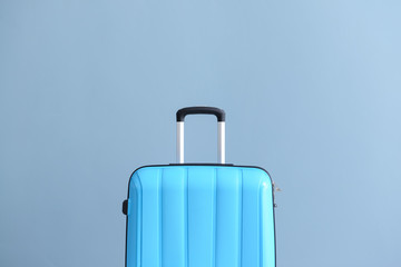 Packed suitcase on color background