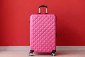 Packed suitcase near color wall