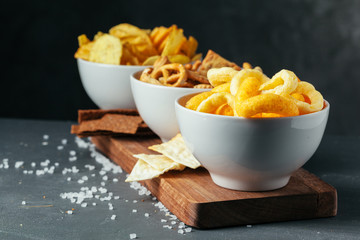 Beer snacks on stone table. Various crackers, potato chips. Top view