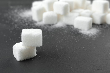 White sugar cubes over black background close up