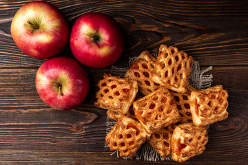 Puff pastry with apple on dark wooden background.