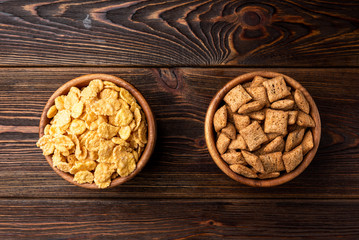 Corn flakes on dark wooden background. 