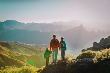 father with son and daughter hiking in mountains