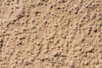 A beautiful horizontal texture of part of an old wall with yellow and orange plaster on the photo