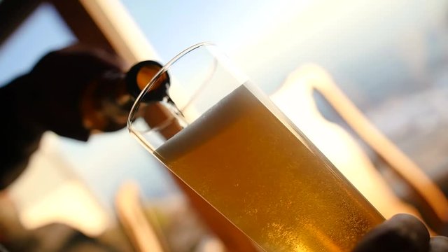 Refreshing beer being poured into glass.