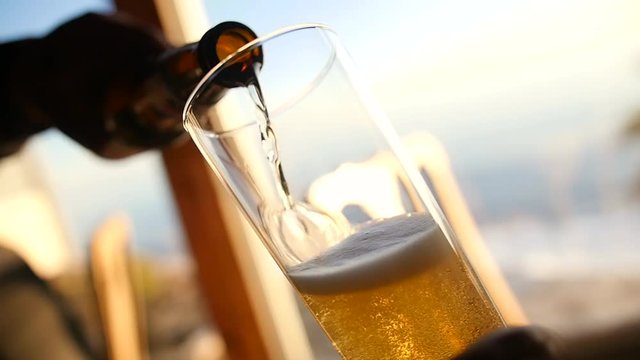 Refreshing beer being poured into glass.