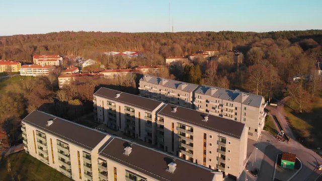 Aerial footage of newly developed apartements in suburb Orgryte torp in Gothenburg, Sweden with forest in the background at sunset