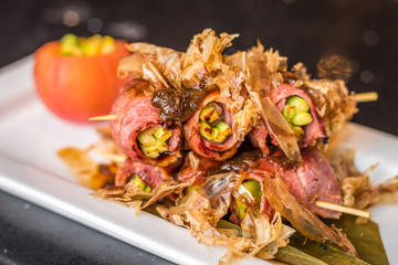 tender asparagus wrapped in beef bacon and grilled then topped with bonito flakes