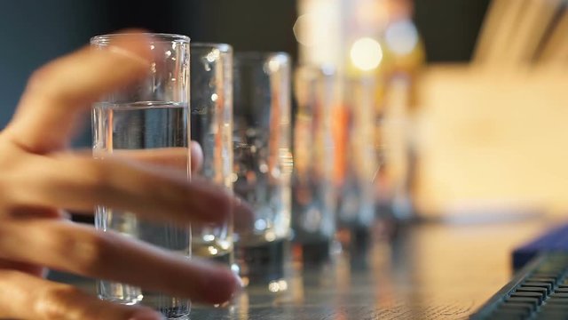 Female drinking alcohol shots on bar counter, party at night club, wasting life