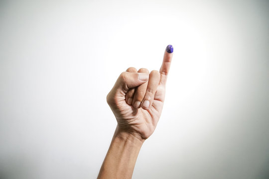 Inked blue finger of a man hand isolated on white background. blue ink blots from voters finger presidential election (pilpres) of indonesia.