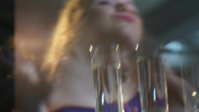 Dancing woman holding shot of alcohol, party all night at club, binge drinking