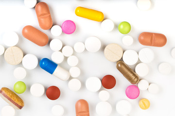 set of multi-colored tablets and capsules on a white background