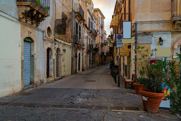 Typical italian narrow street with flower pots in the island of Ortigia, Syracuse, Sicily, Italy
