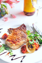 grilled beef steak and vegetables with wine and flowers on white background,