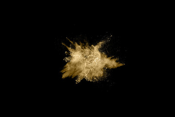 Golden powder explosion on black background. Freeze motion.