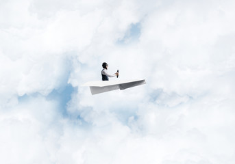 Pilot in leather helmet driving paper plane