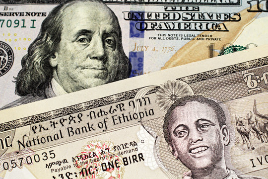 A close up image of a grey one Ethiopian birr bank note in macro with a one hundred American dollar bill 