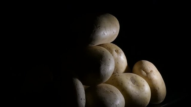 Potatoes vegetables in a mountain on a black tray. Solanum tuberosum