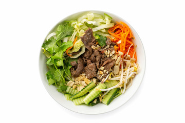 Closeup vietnamese healthy fresh salad of beef meat, bamboo, cabbage, cucumber and carrot served in a bowl isolated at white background.