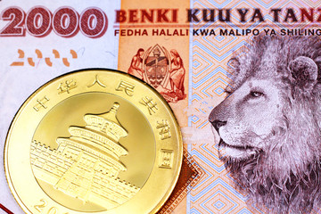A close up image of an orange, Tanzanian two thousand shilling note with a shiny, Chinese panda...