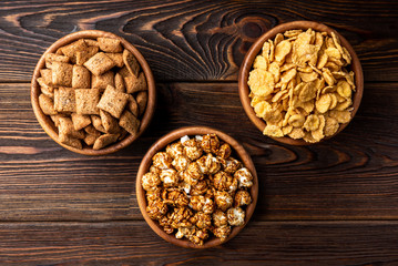 Corn flakes on dark wooden background. 