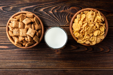 Corn flakes on dark wooden background. 