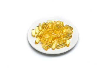 Close up of Gold fish oil capsules isolated in dish on white background. Salmon fish capsules view. Supplement food background. Omega 3. Vitamin E.