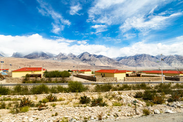 Naklejka premium Xinjiang, China: local villages and mountains on the Pamir Plateau along Karakorum Highway, near Tashkurgan. Connecting Kashgar and the Pakistan Border, this road some of the best views of China