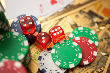 Casino red dices and casino poker chips on golden US Dollar bills