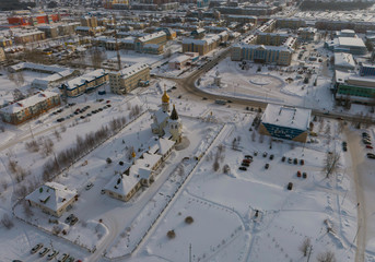 Church and city administration building  in Yugorsk city. Aerial. Winter, snow, cloudy. Khanty Mansiysk Autonomous Okrug (HMAO), Russia.