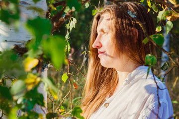Portrait of a young girl among the birches in the forest