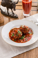 Meatballs in sweet and sour tomato sauce on wooden table