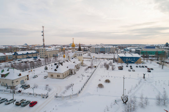 Church and city administration building  in Yugorsk city. Aerial. Winter, snow, cloudy. Khanty Mansiysk Autonomous Okrug (HMAO), Russia.
