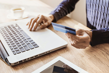 Woman hand holding credit card and using laptop computer. Businesswoman or entrepreneur working....
