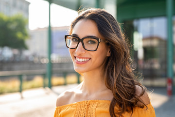 Smiling woman wearing eyeglasses outdoor - obrazy, fototapety, plakaty