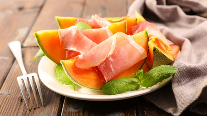 Fototapeta na wymiar melon slices with ham and basil