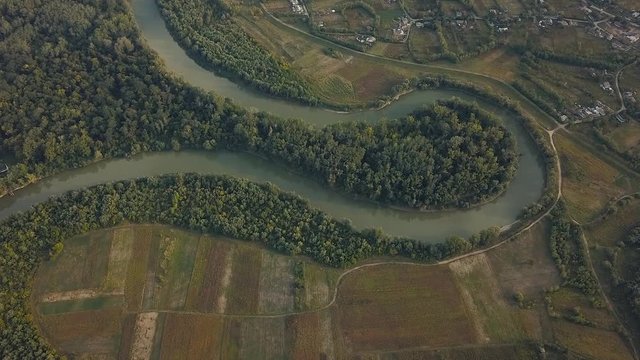 Ornamental birds eye view over green brownish checkered farmlands and the Prut river meander
